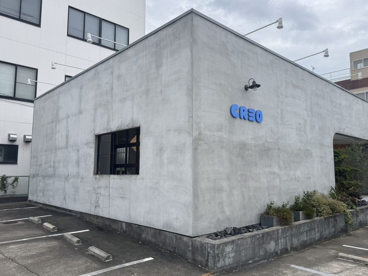 CREOの外観。コンクリートの壁に青い「CREO」のサイン