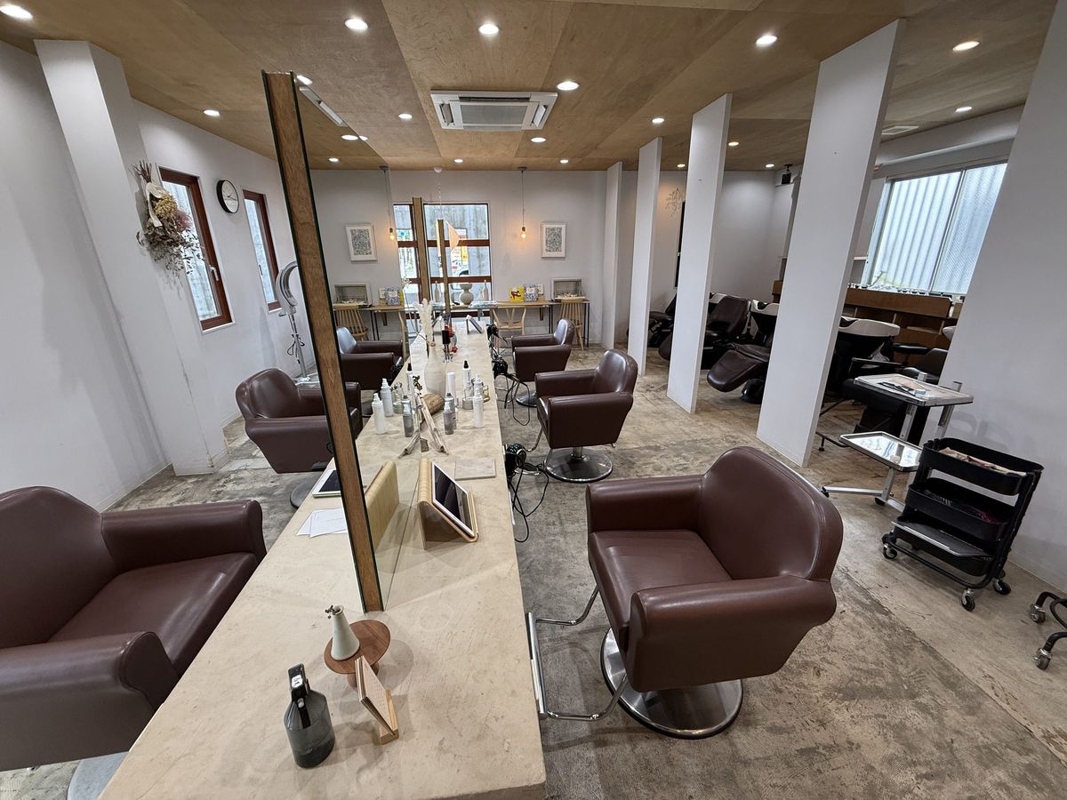 岡崎市の美容室CREOの店内。木の天井と白い壁、ブラウンのスタイリングチェア
