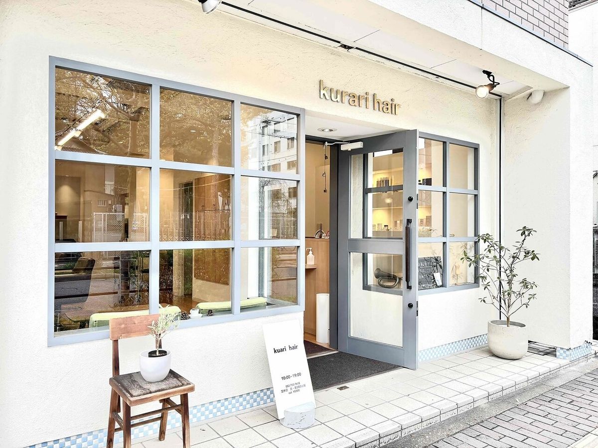 kurari hairの外観。白い外壁に「kurari hair」のサインとガラスの入口
